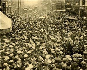A city street filled with hundreds of people.